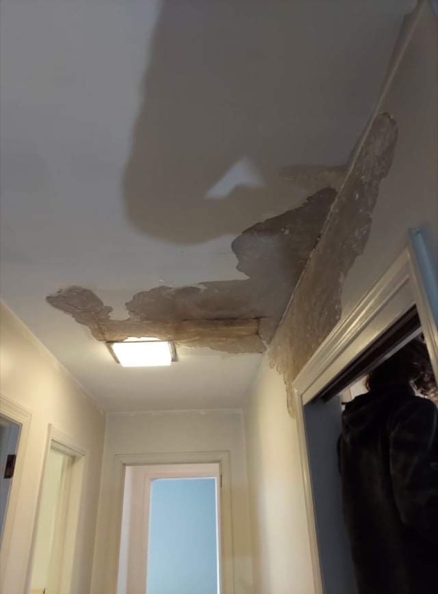 Hallway ceiling before repair — plaster stripped to bare substrate
