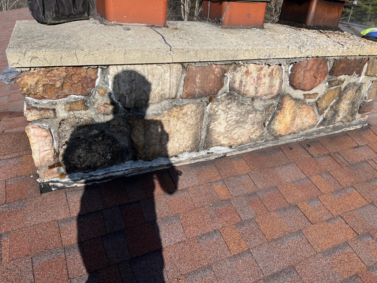 Chimney before repair — cracked crown, failed mortar and rusted flashing