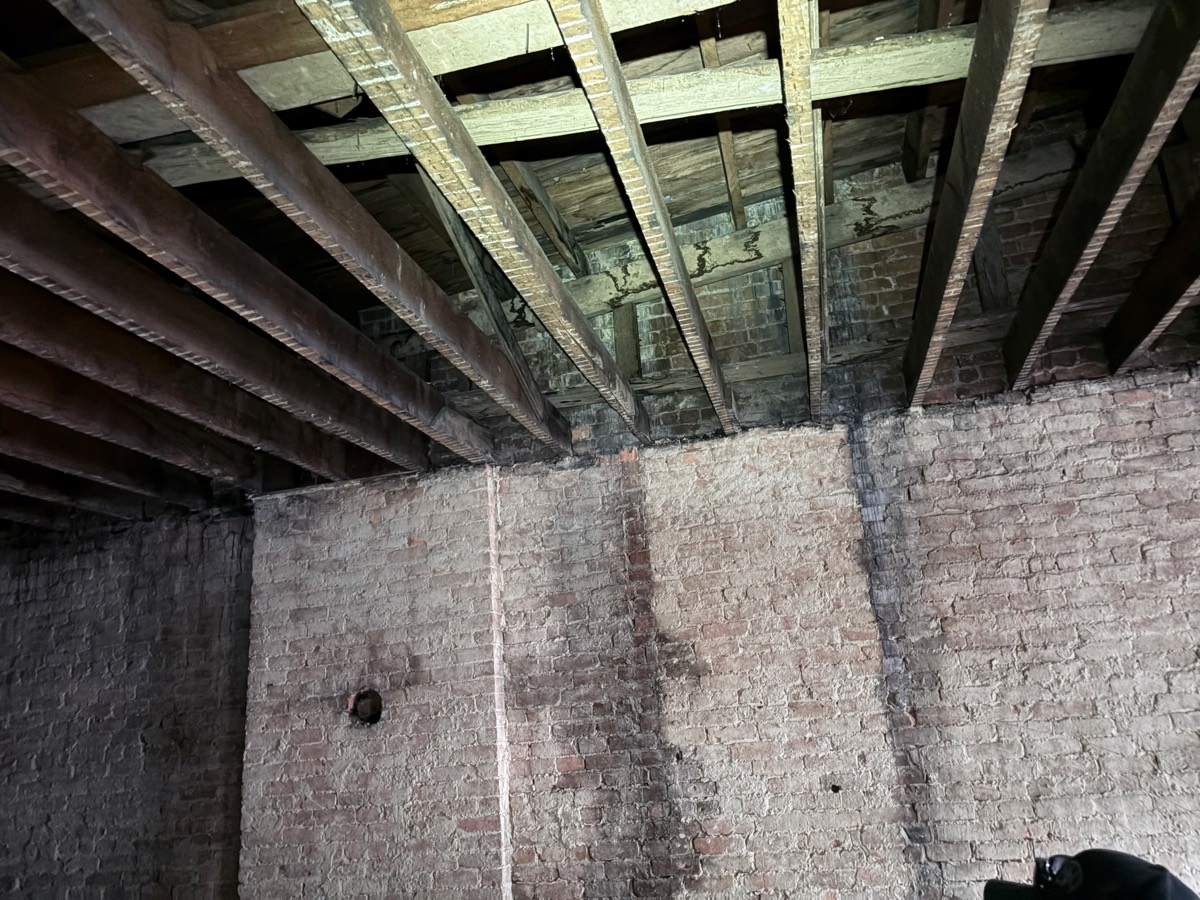Commercial interior before renovation — gutted to brick and joists