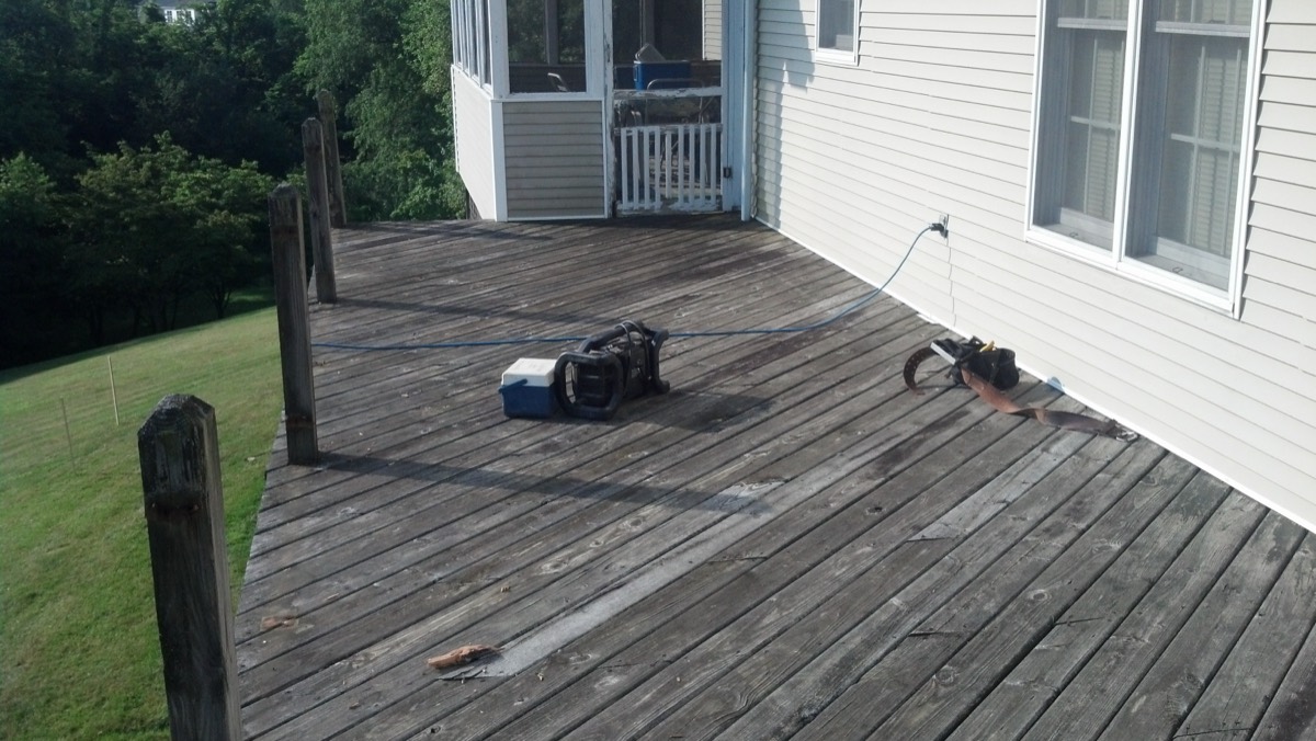 Deck before rebuild — weathered gray boards and rotting posts