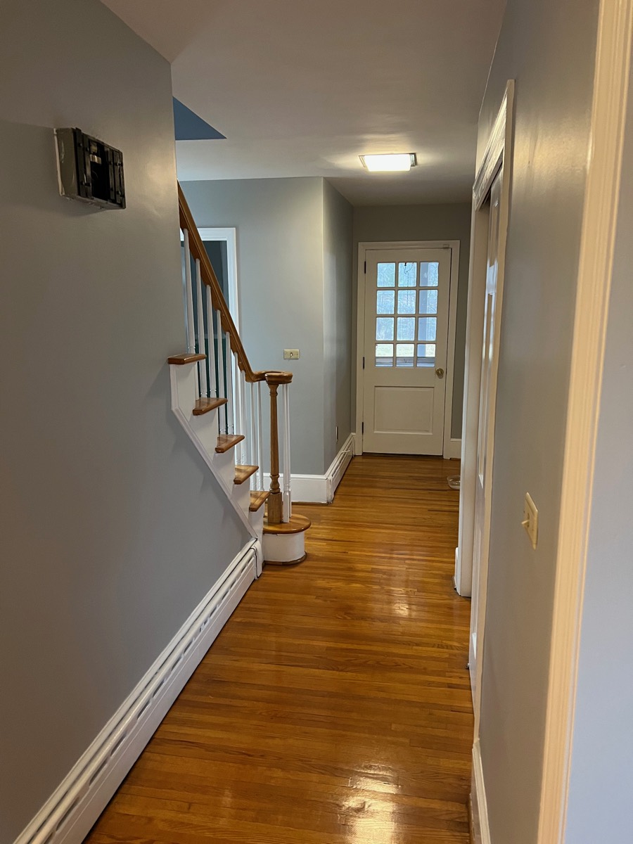 Hallway and staircase after painting — gray walls with crisp white trim
