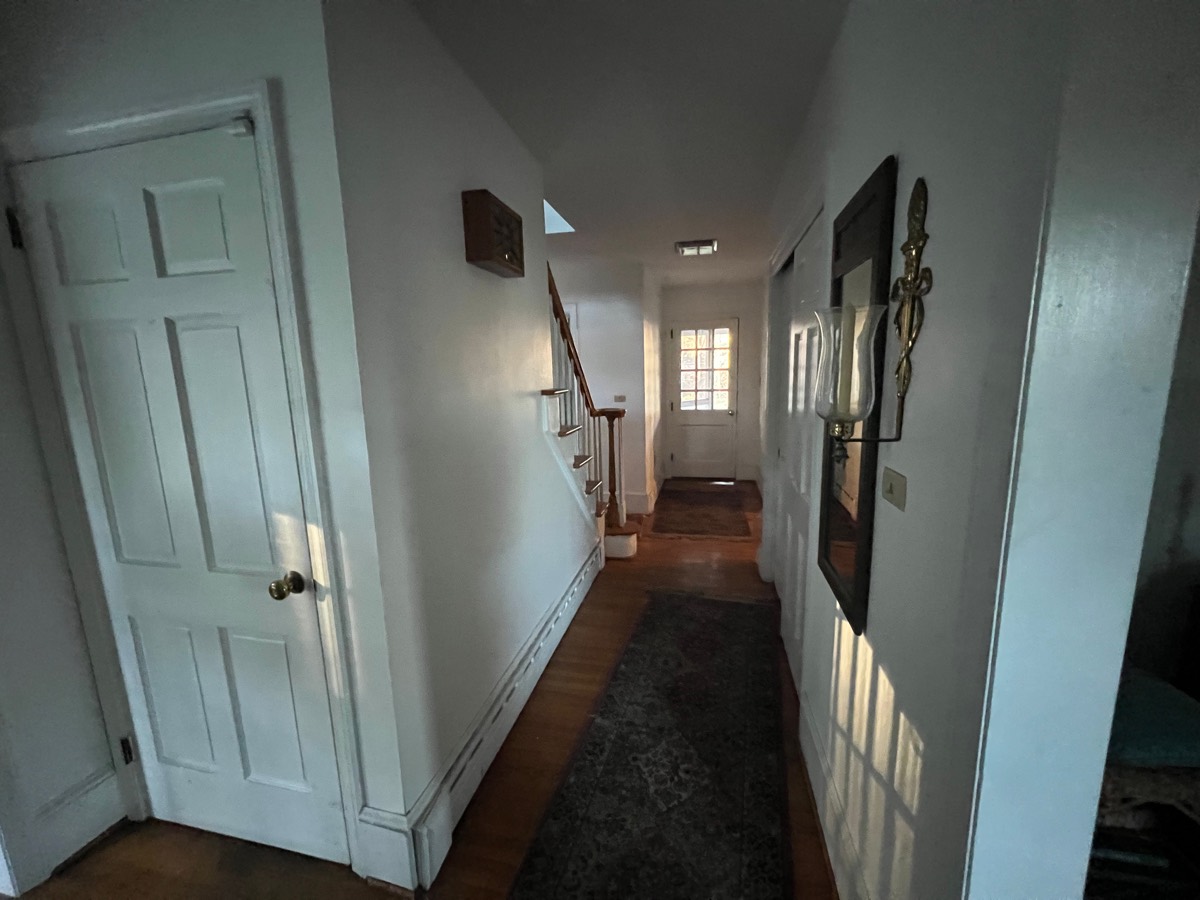 Hallway and staircase before painting — dim, dated walls