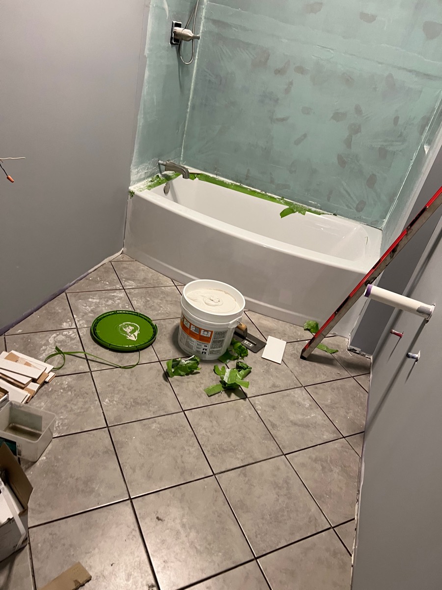 Tub surround before tile — green waterproofing membrane applied